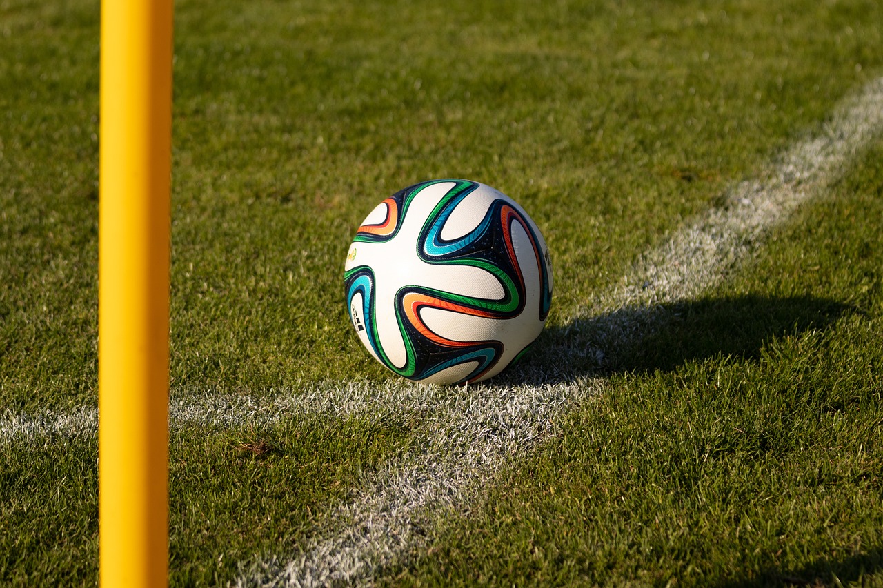 Soccer ball sitting on corner of soccer filed