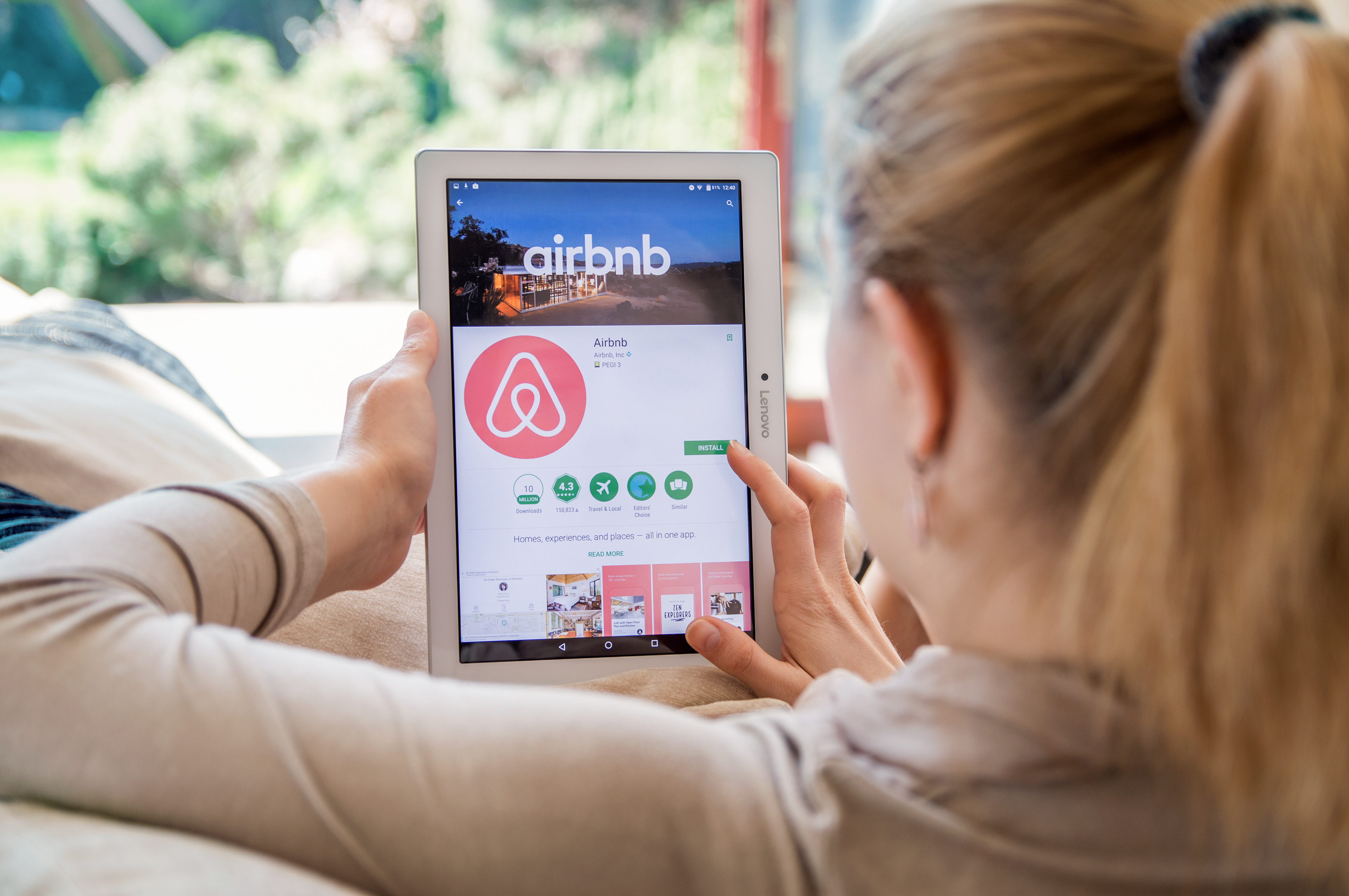 woman looking at Airbnb app on her iPad