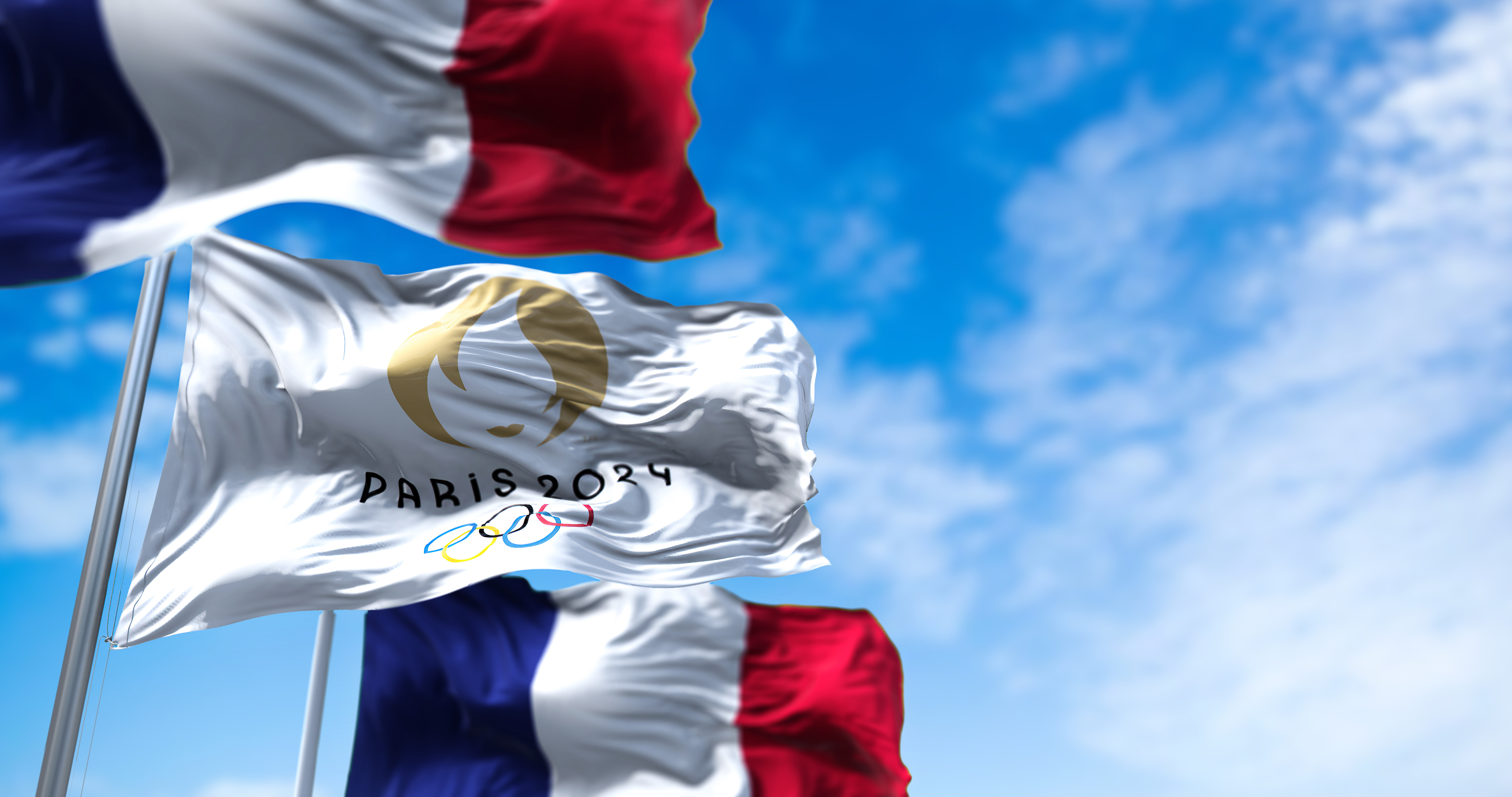 flags blowing in the wind of France and the Paris Olympics 2024 flag