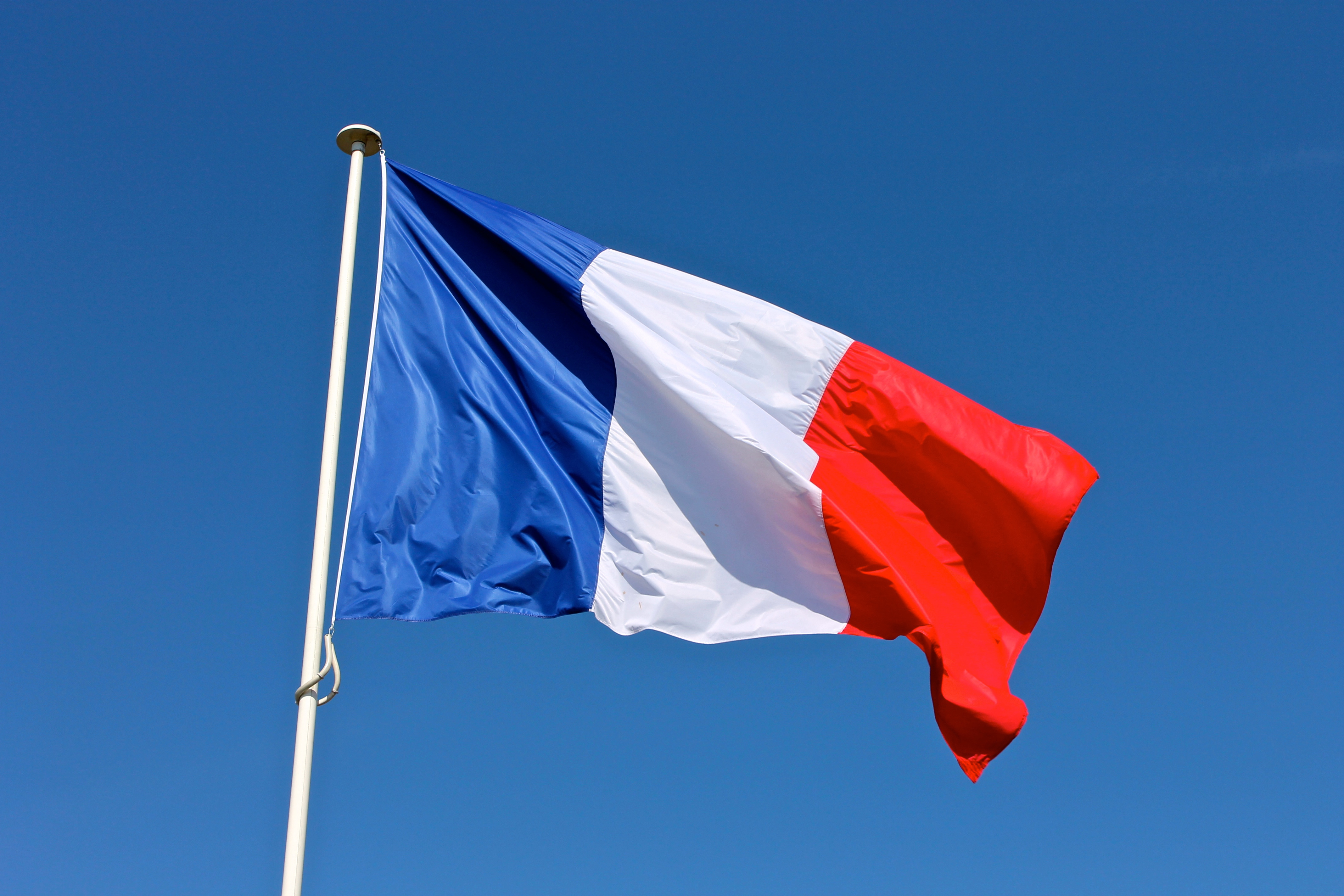 French flag flying against a blue sky