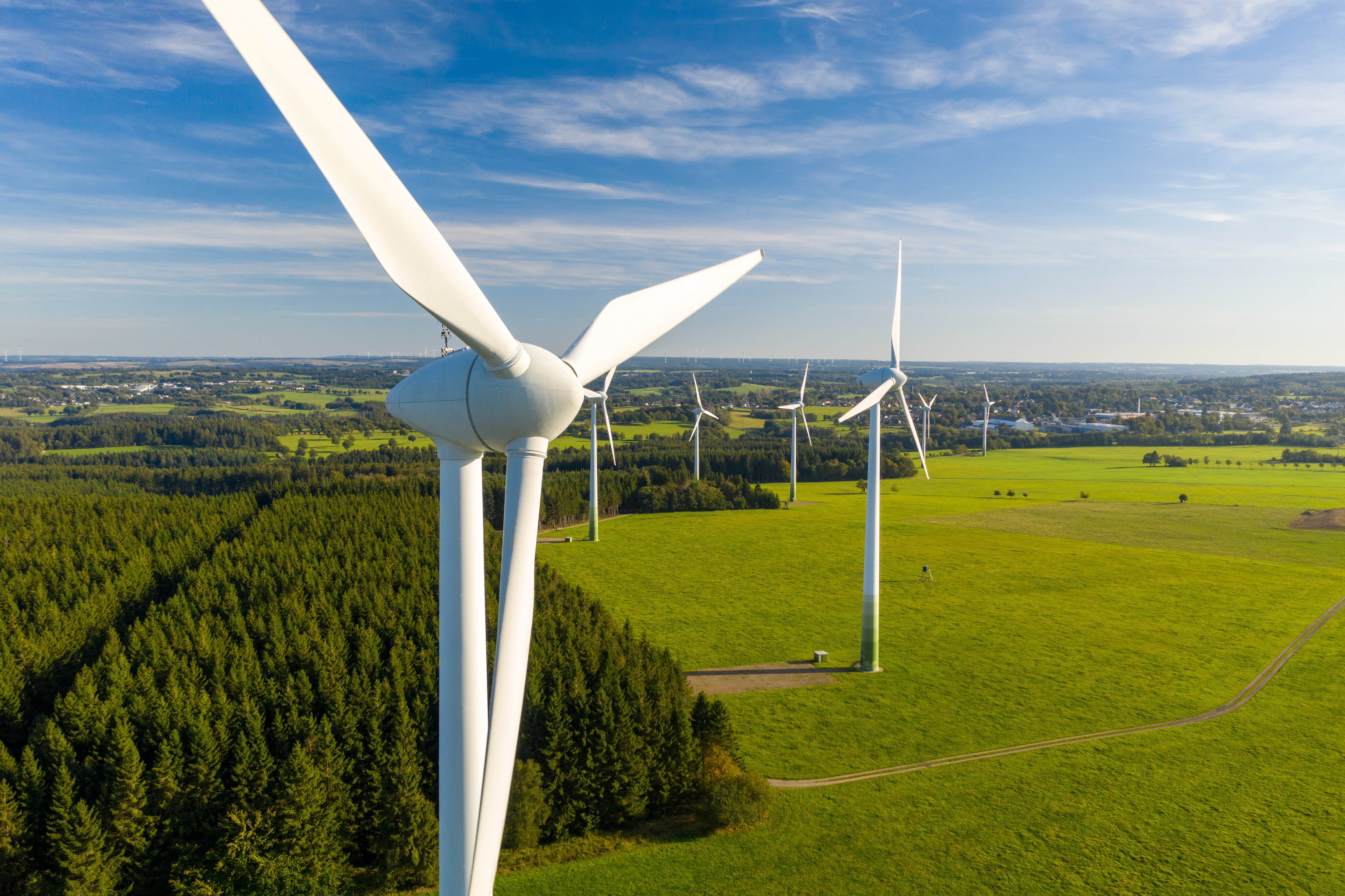 wind turbine with green land and blue skies in the background
