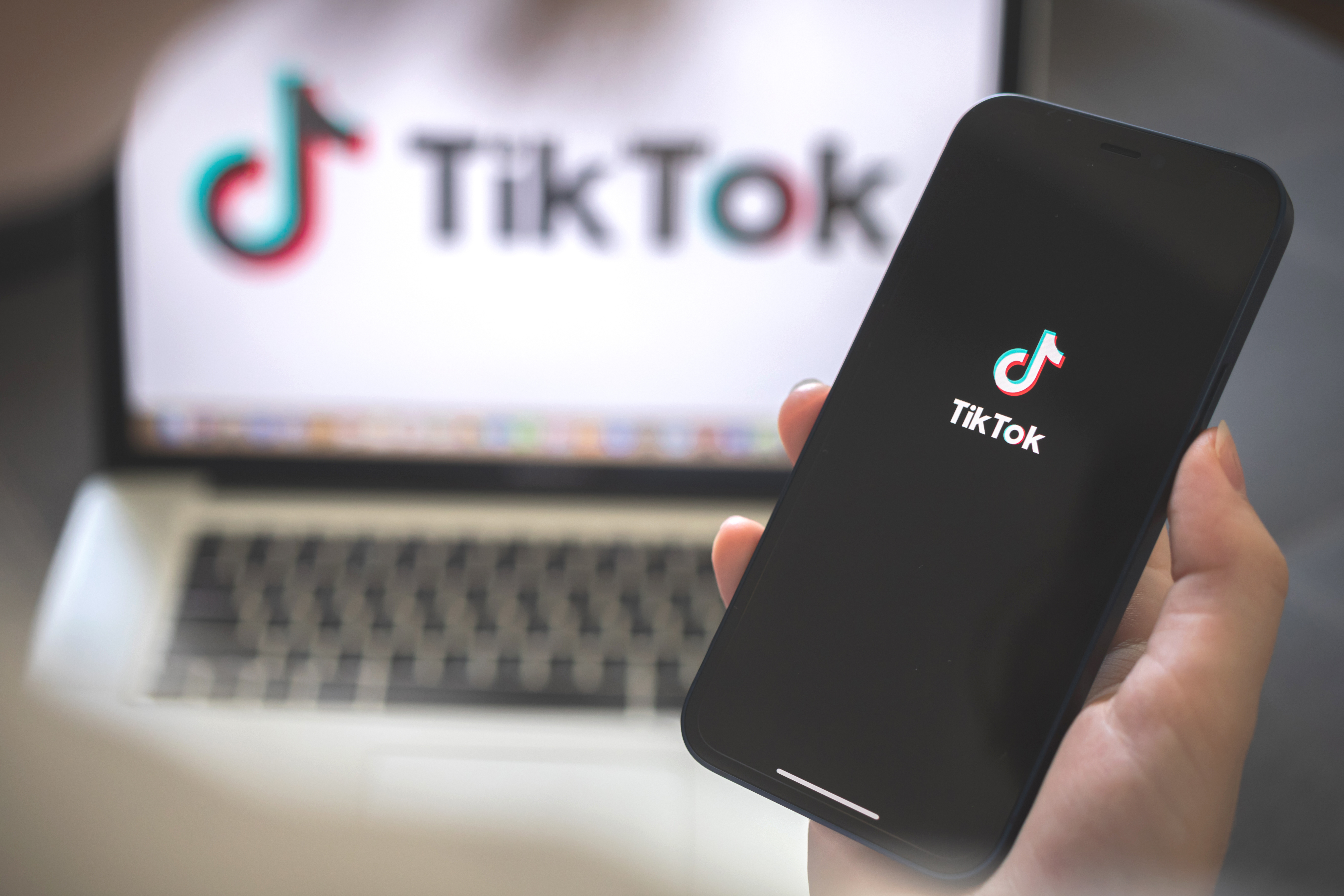 TikTok logo on a phone and a computer screen