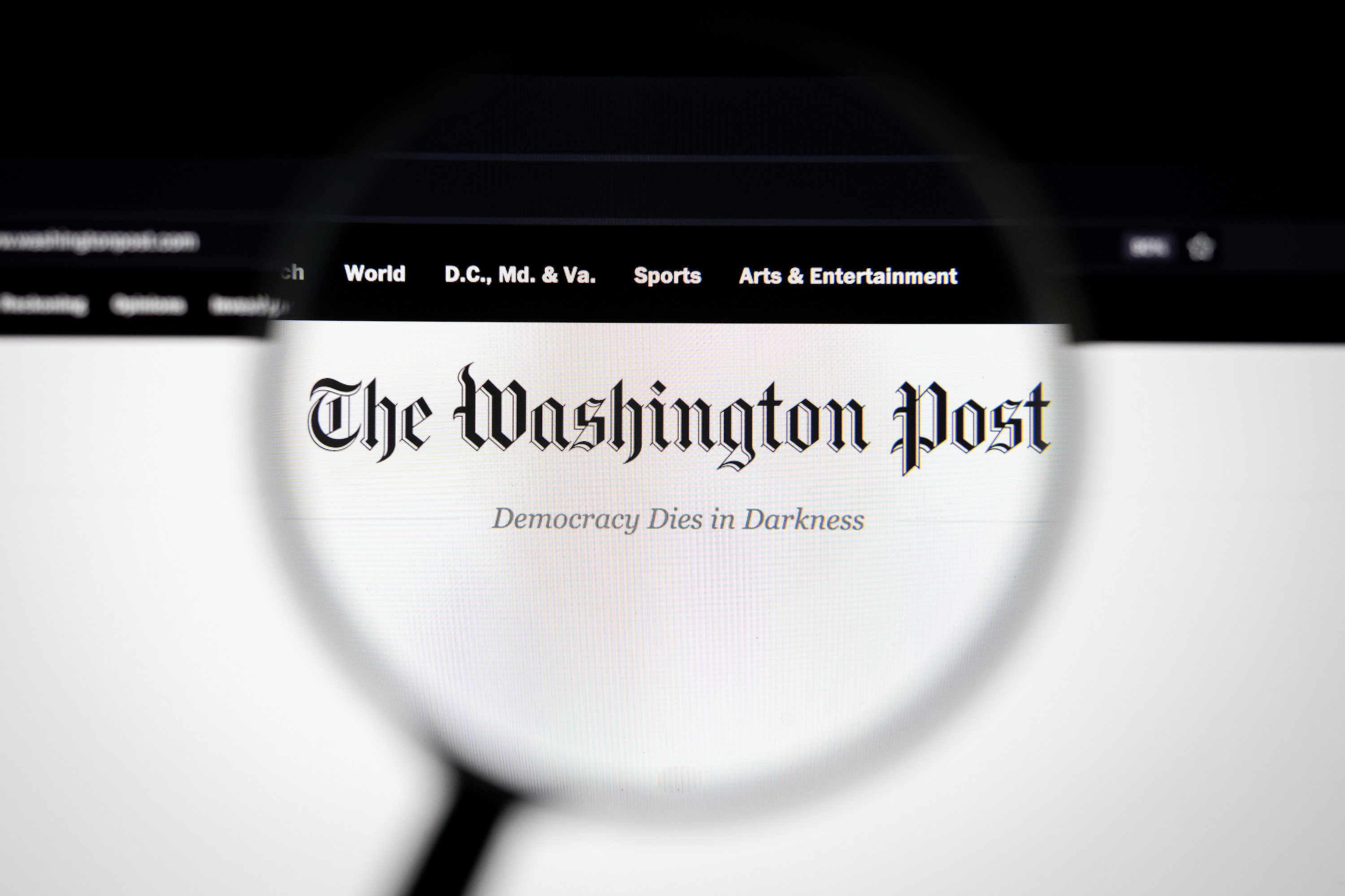 Magnifying glass hovering over Washington Post newspaper logo