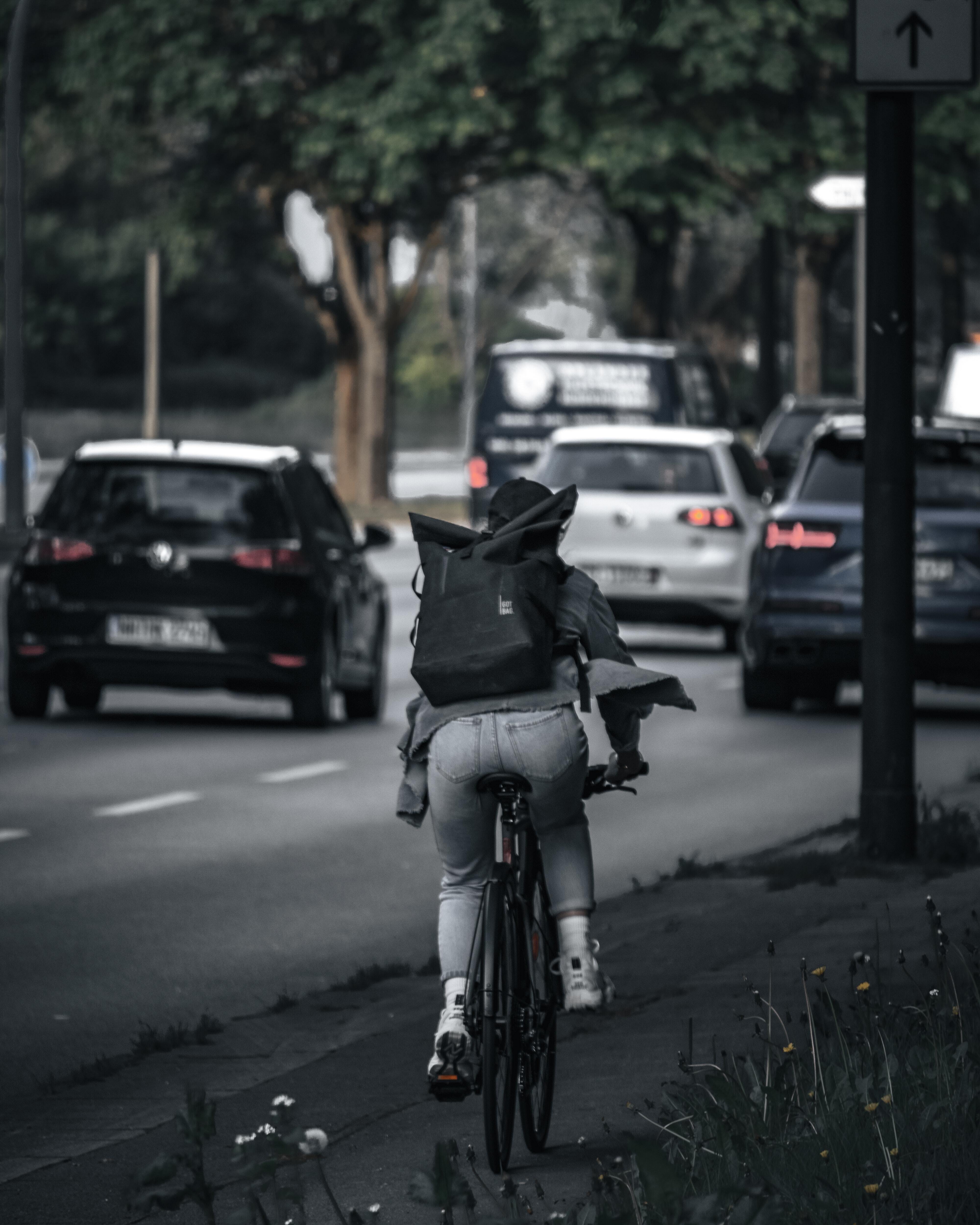 Man riding bike near cars 