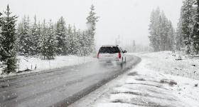 Car traveling on snowy road during winter weather conditions