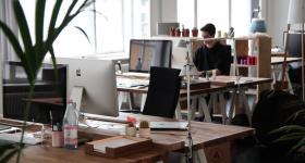 Workplace that shows empty desks and people at work
