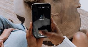 Person holding phone with the TikTok homescreen open
