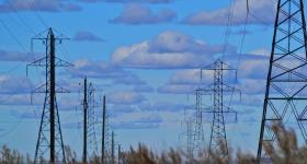 electrical power lines with a blue and cloudy sky backdrop