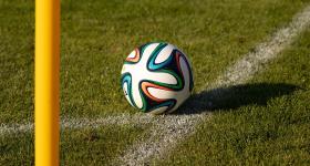 Soccer ball sitting on corner of soccer filed