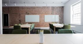 Empty office space with clear desks and a brick wall