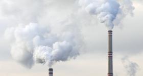 coal plant with smoke coming out of the chimney stacks