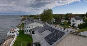 birds eye view of solar panels on a home along the water