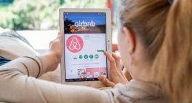 woman looking at Airbnb app on her iPad