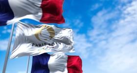 flags blowing in the wind of France and the Paris Olympics 2024 flag