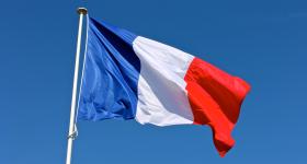 French flag flying against a blue sky