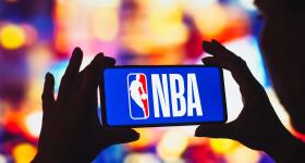 person holding a phone with a NBA logo on the screen