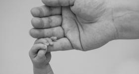 adult holding a baby's hand