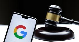 Google logo on a smartphone with a judge gavel in the background