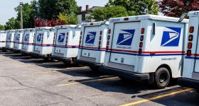 US Postal Service trucks parked in a lot