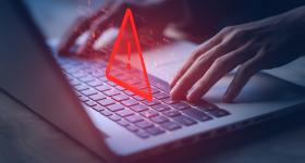 keyboard with a red triangle above to illustrate a scam