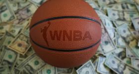 WNBA logo on a basketball with money in the background